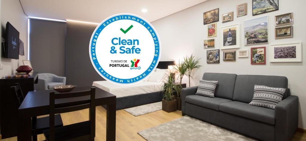 a living room with a couch and a sign for clean and safe at Bugalha My Loft Douro 1 in Peso da Régua
