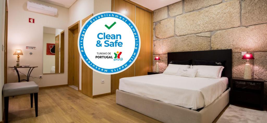 ペーゾ・ダ・レーグアにあるBugalha My Loft Douro 7のベッド1台、清潔で安全なサインが備わるホテルルームです。