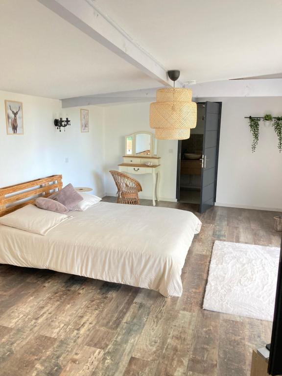 a bedroom with a large bed and a table at Villa Nymphea in Saint-Pierre-dʼAutils