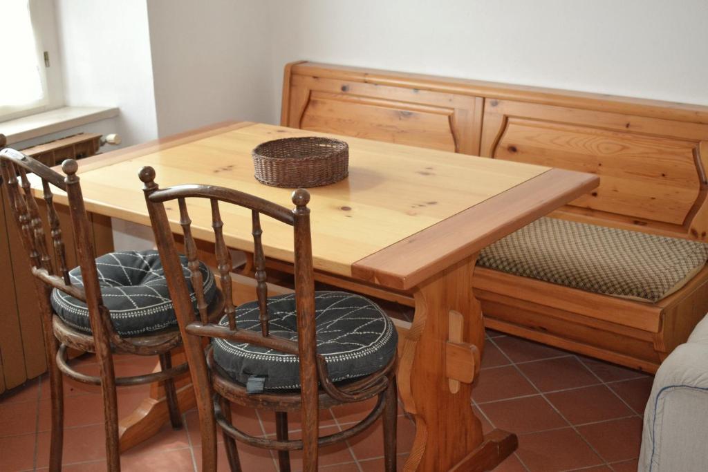a wooden table with two chairs and a wooden bench at Apartma Raft, Bovec in Bovec