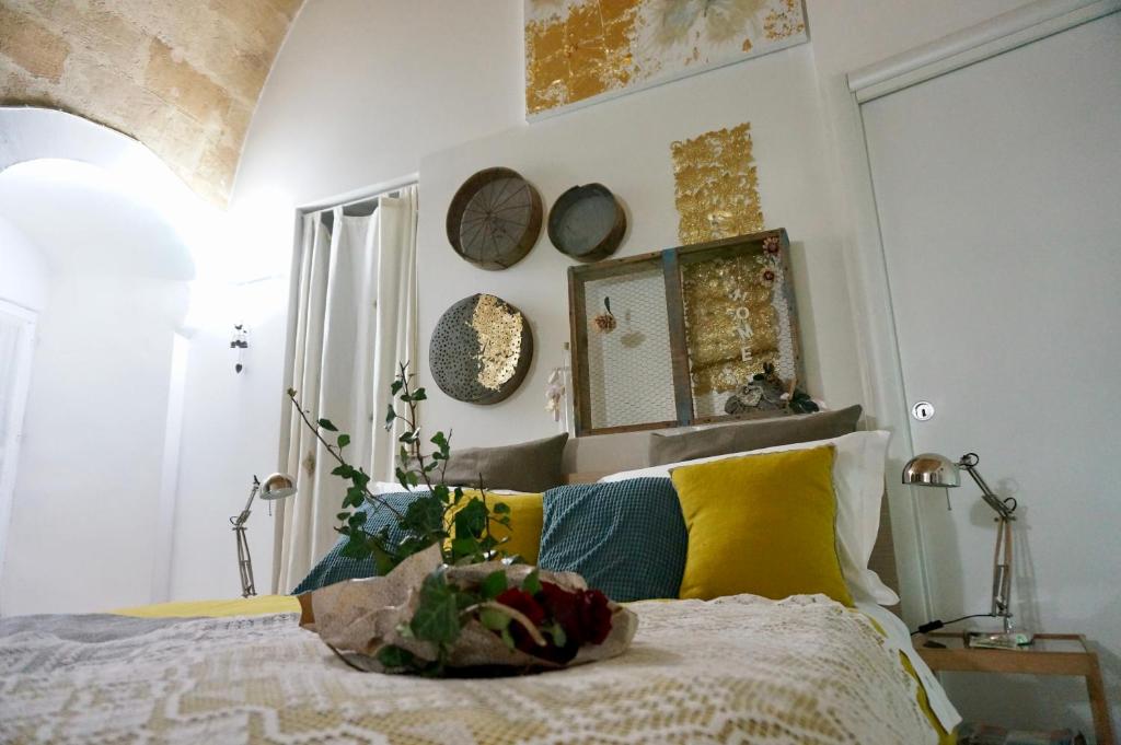 um quarto com uma cama com almofadas amarelas e azuis em Il Geco em Matera