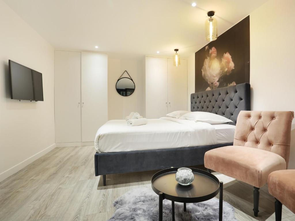 une chambre avec un lit, une télévision et un canapé dans l'établissement Rent a Room - Apartment St Honore, à Paris