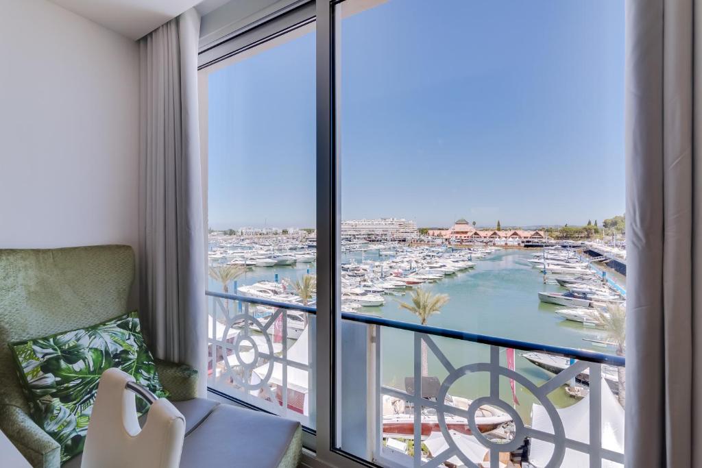 a room with a balcony with a view of a harbor at Gold Suites - Luxurious apartment - Sea view in Vilamoura