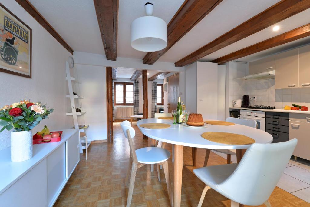 een keuken en eetkamer met een witte tafel en stoelen bij Appartement La Grande Terrasse du Centre in Colmar