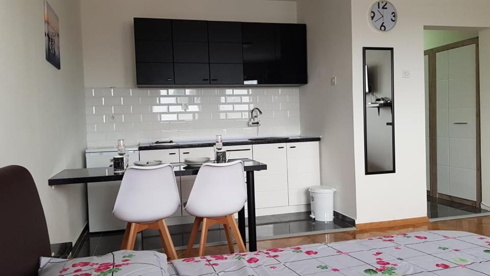 a kitchen with a counter and two white stools at CENTRAL VIEW APARTMENT in Skopje