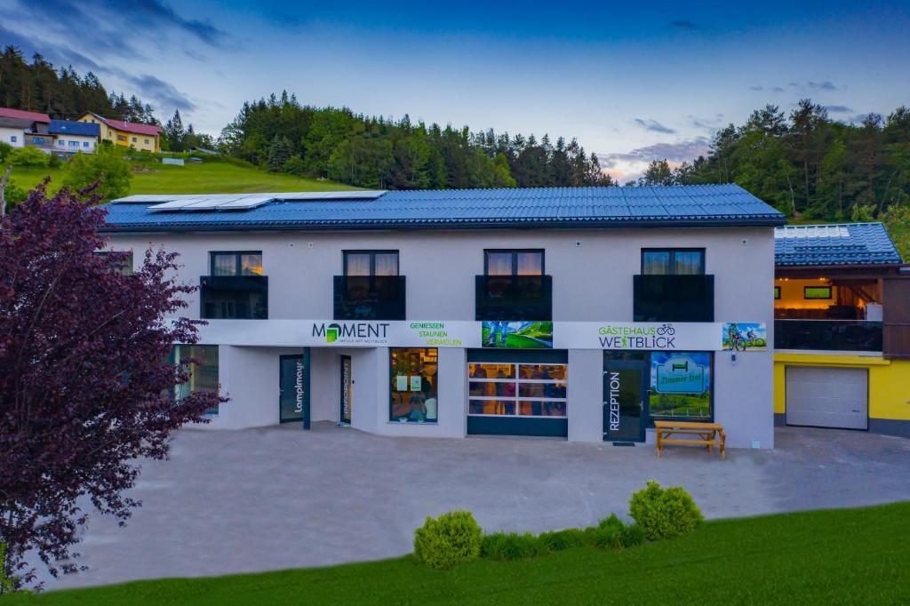 a white building with a blue roof at Gästehaus Weitblick in Sankt Leonhard bei Freistadt