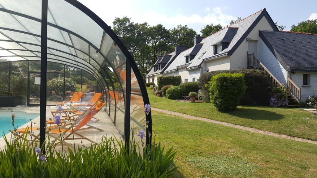 a view of a yard with a pool and houses at l'Arbre Voyageur in Locoal-Mendon