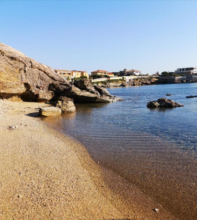 une plage avec des rochers dans l'eau par beau temps dans l'établissement Maison Bord de Mer, à Six-Fours-les-Plages