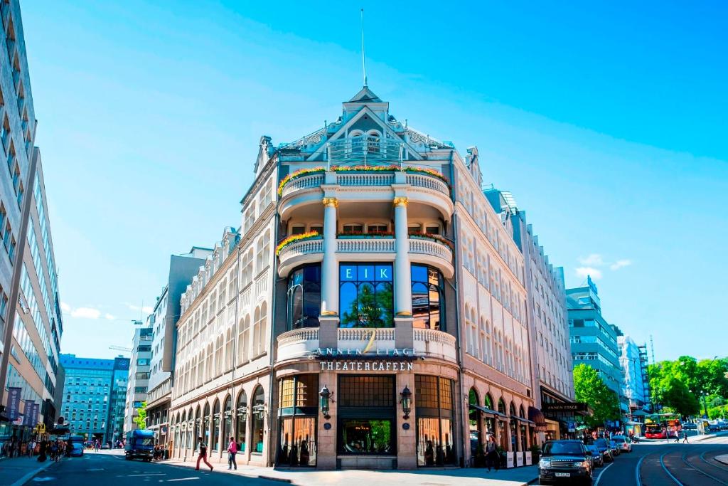 a large building on a city street with cars on the street at Hotel Continental in Oslo
