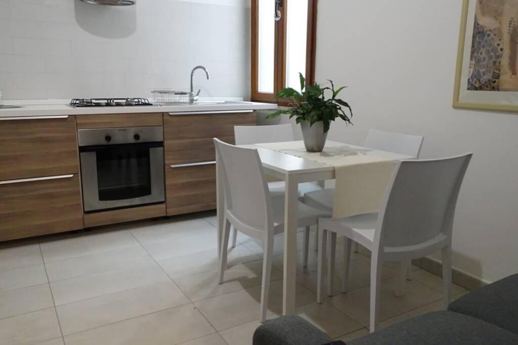 a kitchen with a white table and chairs and a stove at Your House in Olbia