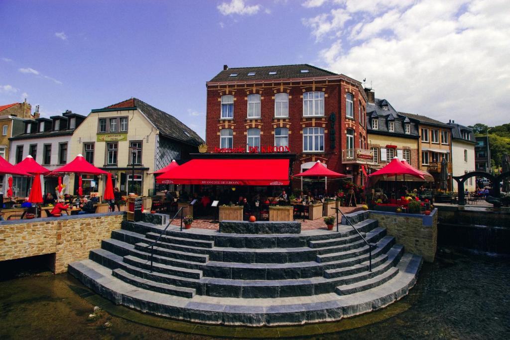 un groupe d'escaliers dans une ville avec des parapluies rouges dans l'établissement Hotel Brasserie de Kroon, à Gulpen