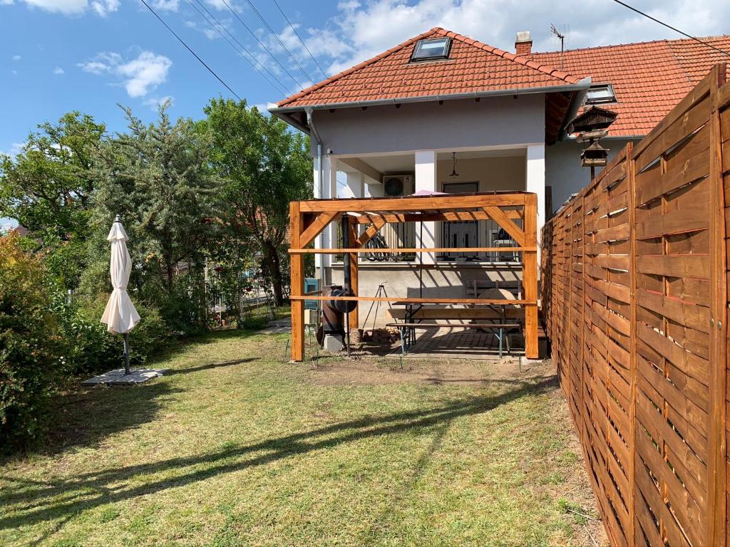 a wooden fence in front of a house at Greenapple Apartman Badacsony in Badacsonytördemic