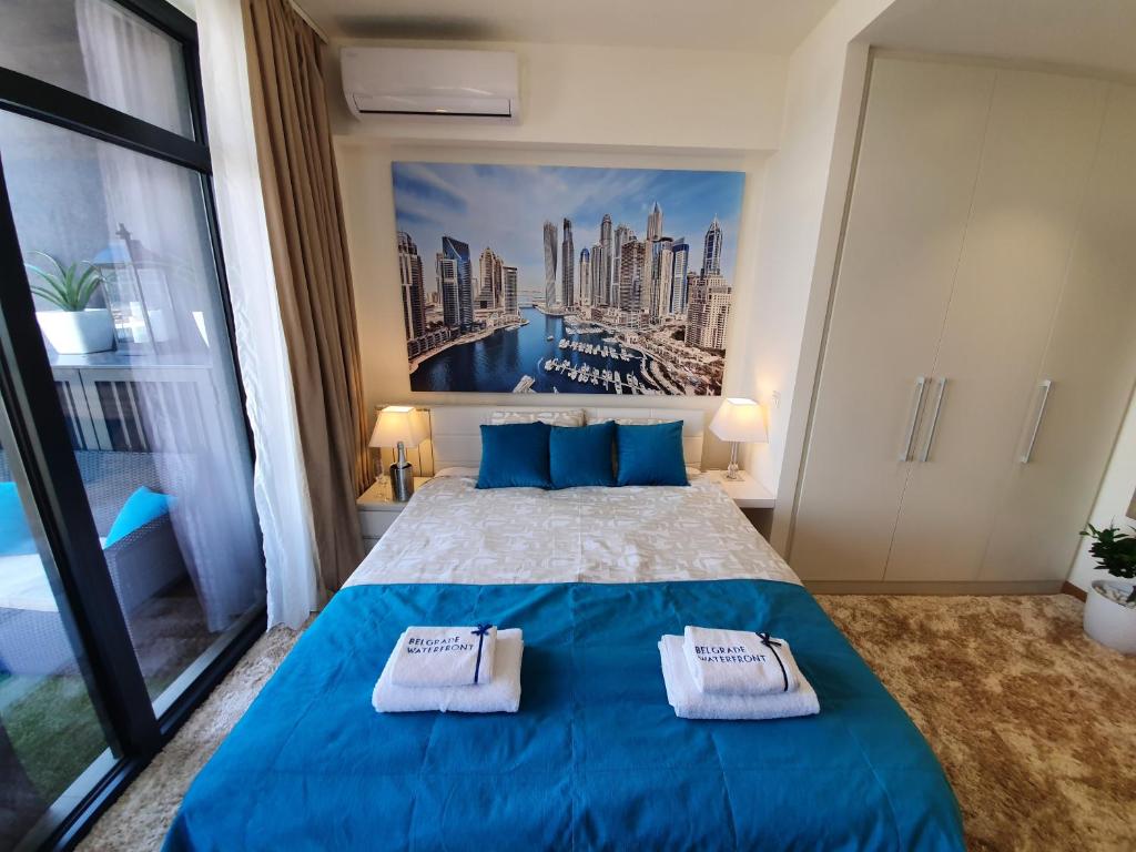 una camera da letto con un letto blu con due asciugamani di Belgrade Waterfront - Beograd na vodi a Belgrado