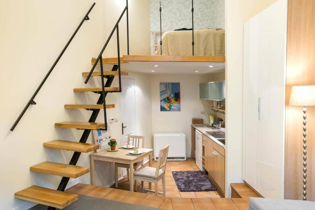 ein kleines Apartment mit einer Treppe, einem Tisch und einer Küche in der Unterkunft Supercute mini house in the center in Krakau