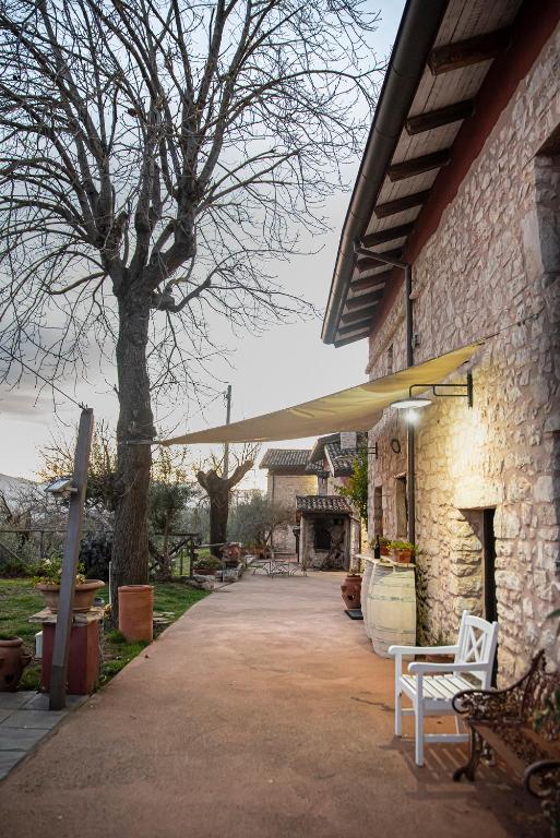 a patio with a table and a yellow umbrella at Il giardino dei mandorli Agriturismo in Alatri