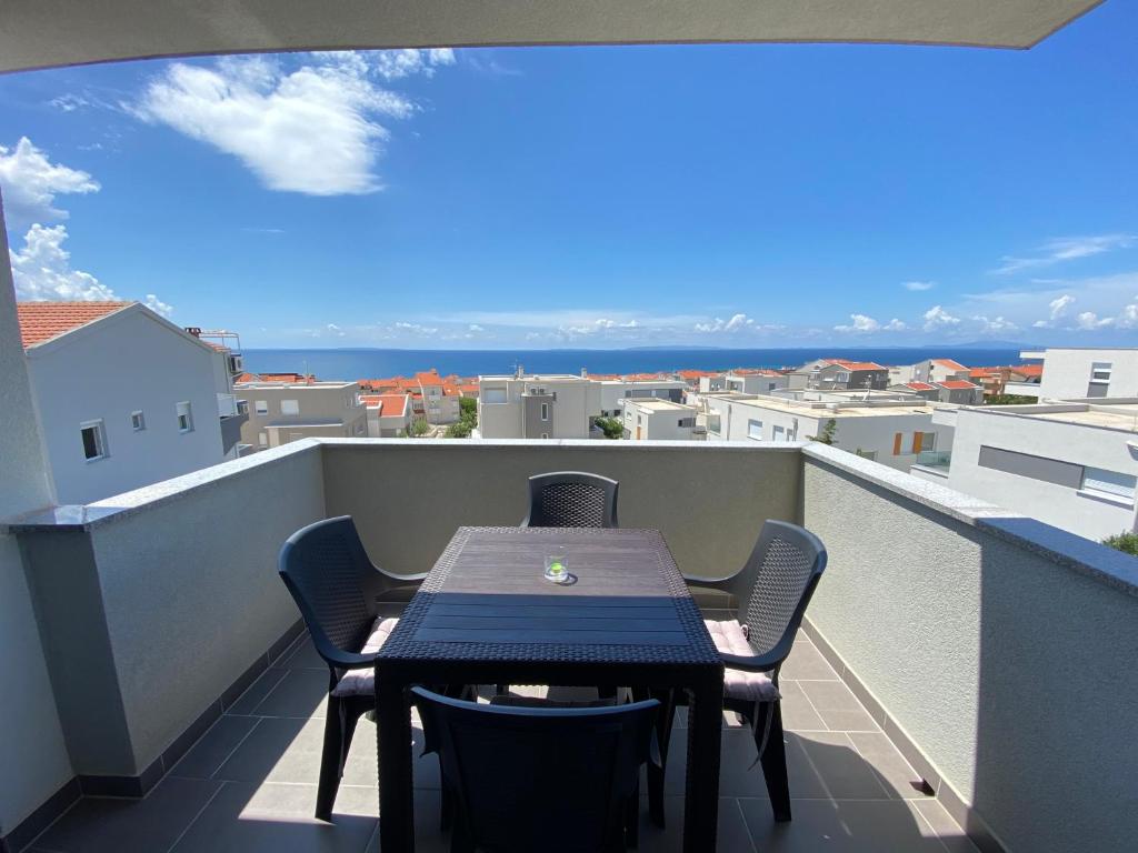 a table on a balcony with a view of the ocean at Apartment Emmy in Novalja