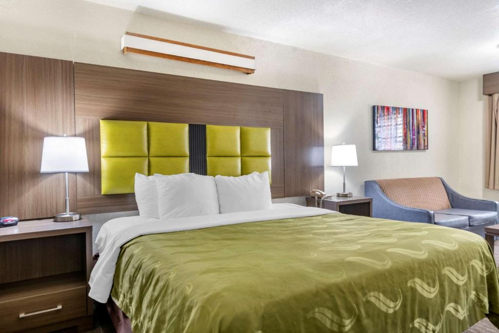um quarto de hotel com uma cama grande e uma cadeira em Quality Inn San Angelo em San Angelo