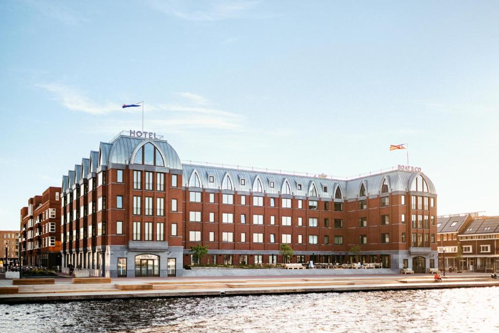 un gran edificio junto a una masa de agua en The July - Boat & Co en Ámsterdam