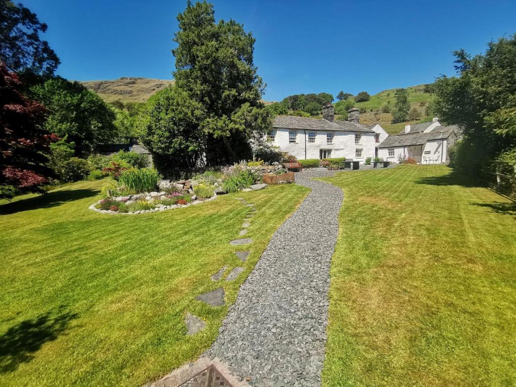 a garden with a gravel path in front of a house at Seatoller House in Borrowdale