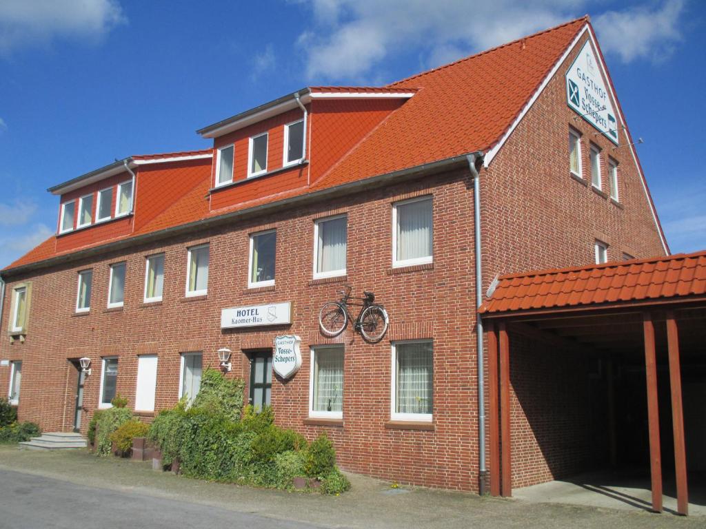 een groot gebouw van rode baksteen met een fiets erop bij Landhotel Vosse-Schepers in Rhede