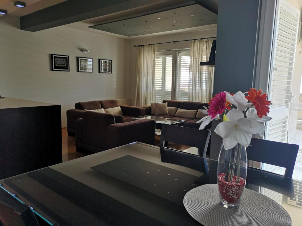 a living room with a vase of flowers on a table at Apartment SeaSun in Makarska