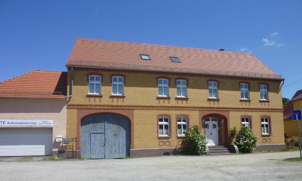 a large brick building with a garage at großes Apartment mit Garten - 4 km bis zum Strand in Senftenberg