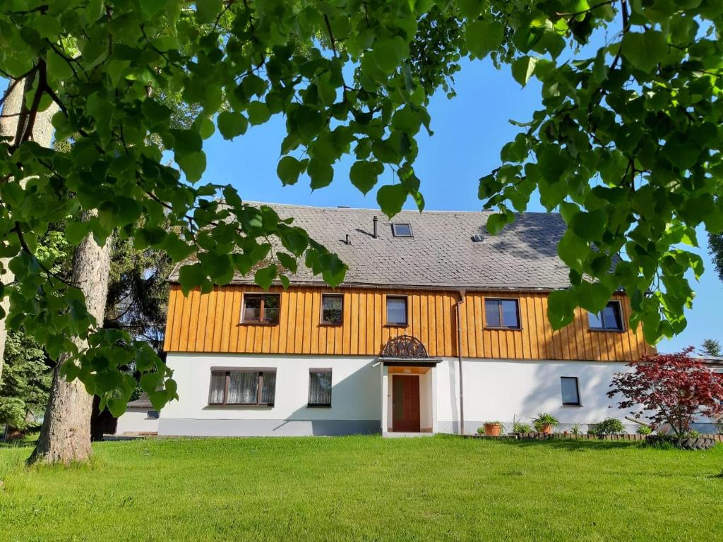 Casa blanca grande con techo de madera en Familienfreundliche Ferienwohnung, en Zschorlau