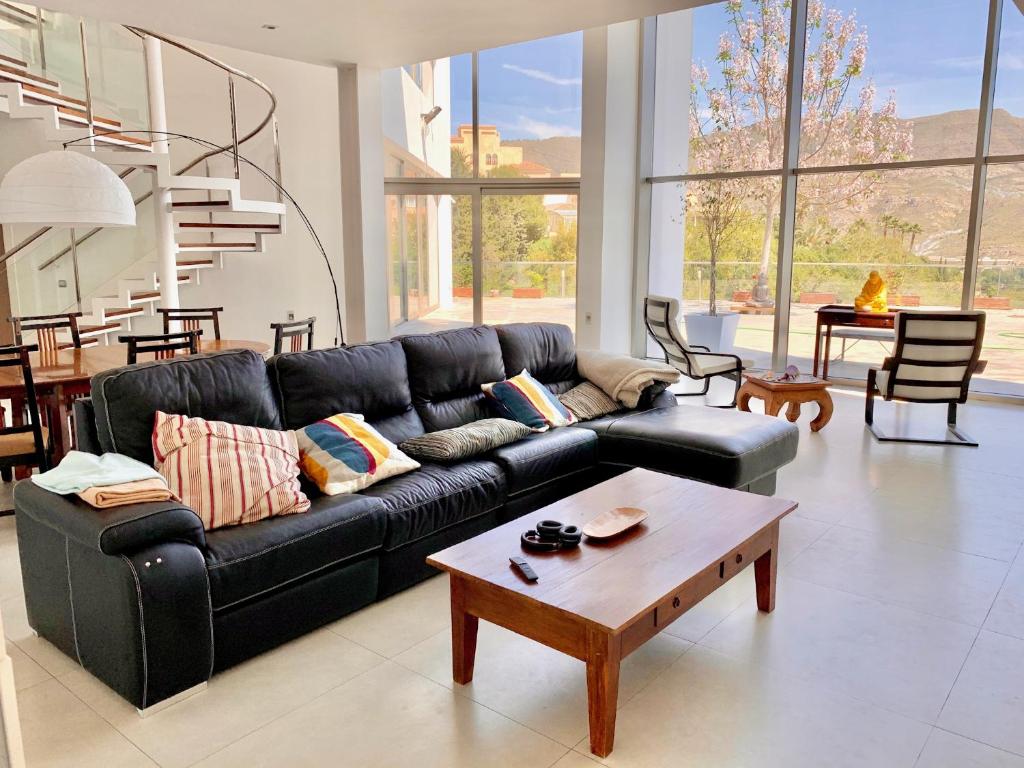 a living room with a black couch and a coffee table at Casa Murasaki in La Envia