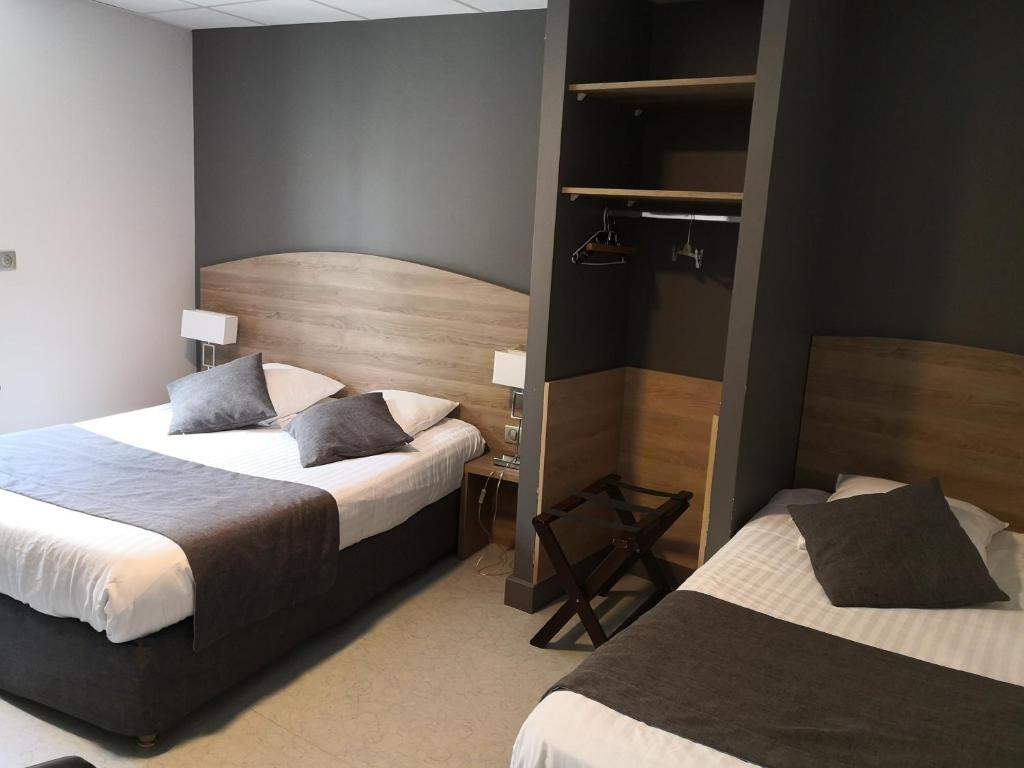 a hotel room with two beds in a room at Hotel du Commerce in Châtillon-sur-Chalaronne