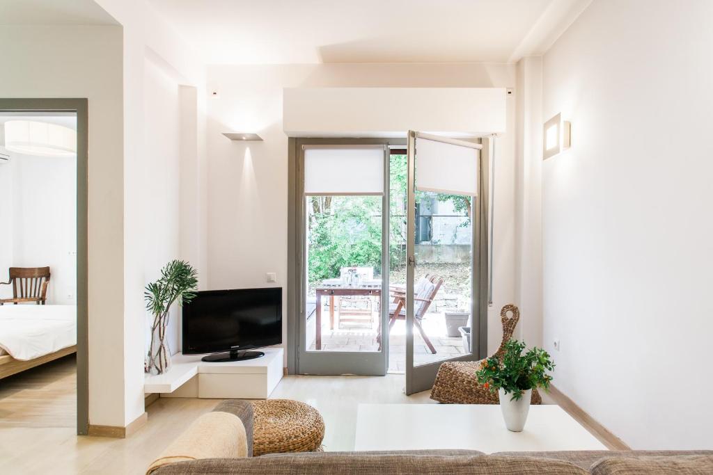 Homz AH19 Psychiko Apartment في أثينا: غرفة معيشة بها أريكة وتلفزيون