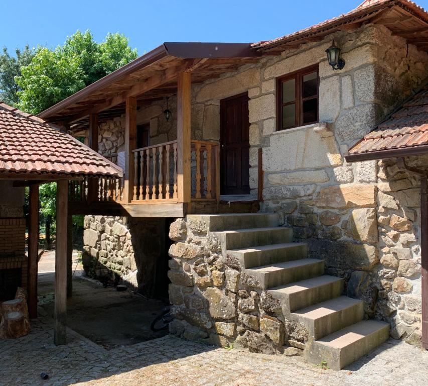 une maison en pierre avec des escaliers menant à une terrasse couverte dans l'établissement Casas do Souto, à Lousada
