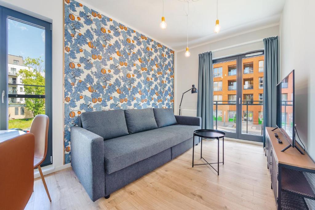 a living room with a couch and a table at Apartamenty Sun & Snow Aura III in Gdańsk