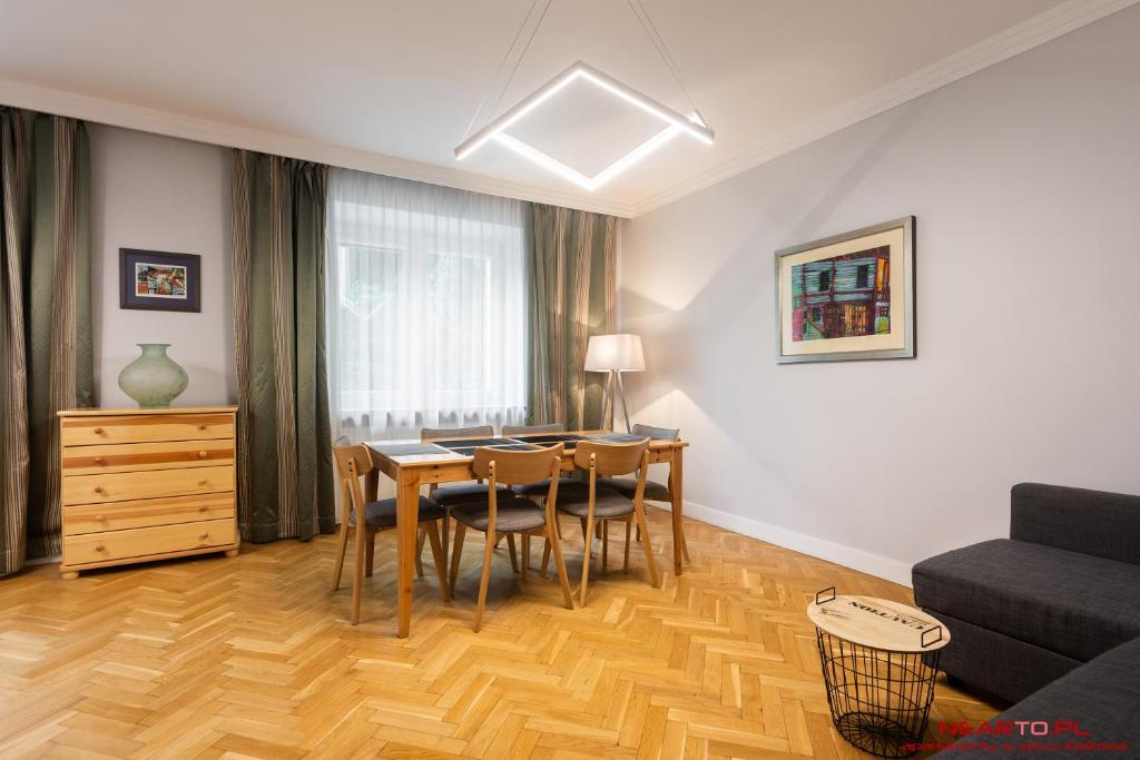 a living room with a table and chairs and a couch at Apartment Nearto Old Town Daszyńskiego street in Krakow