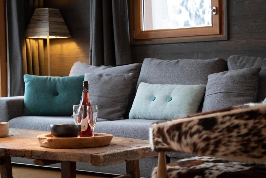 ein Wohnzimmer mit einem Sofa und einem Tisch mit einer Flasche Champagner in der Unterkunft Residence Miravidi La Rosiere in La Rosière