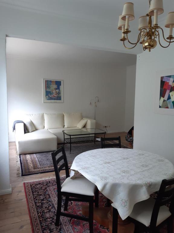 ein Wohnzimmer mit einem Tisch und einem weißen Sofa in der Unterkunft Ganze Wohnung mit Garten in Bremen