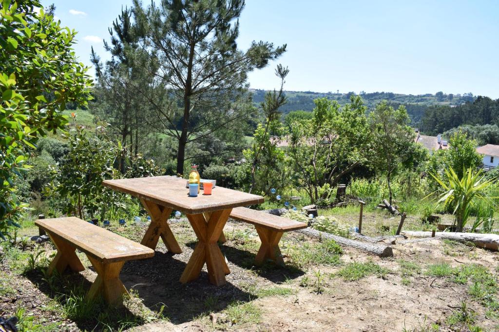 a picnic table with two benches in a field at Vale da Palha in Casal do Pardo