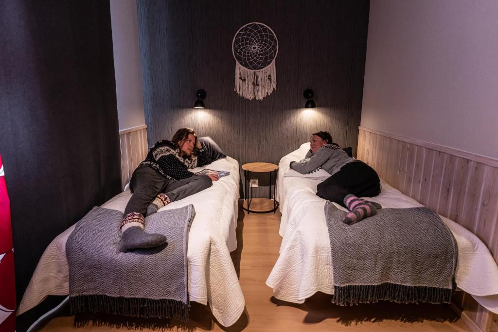 um grupo de pessoas deitadas em camas num quarto em Isokenkäisten Klubi - Wilderness Lodge em Kiviperä