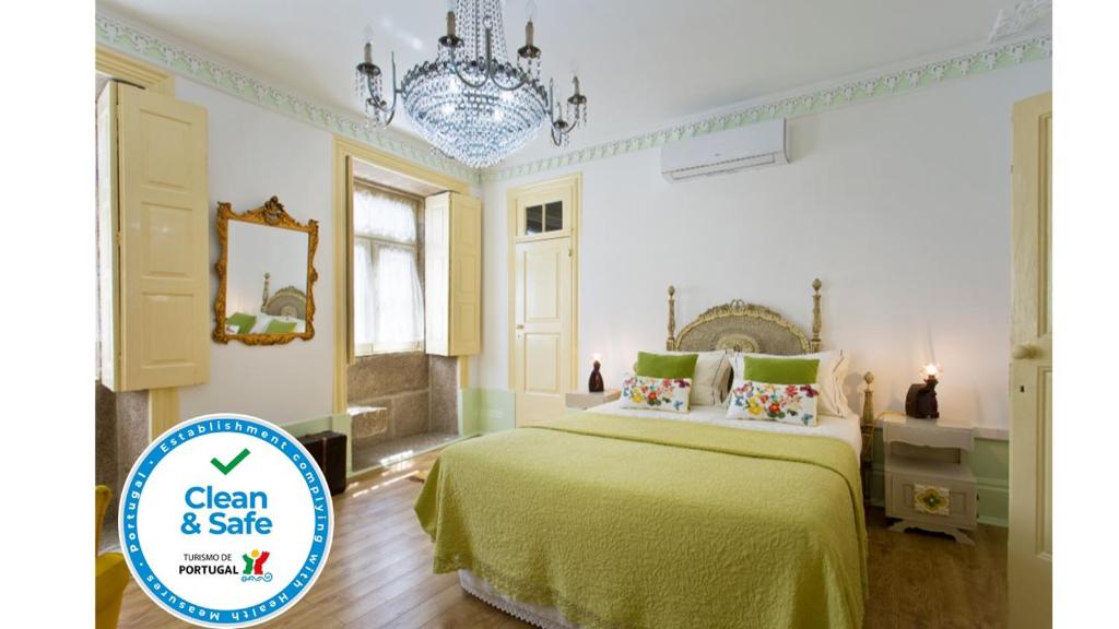 ヴィラ・ノヴァ・デ・ガイアにあるHC Villa Douroのベッドルーム(緑のベッド1台、シャンデリア付)