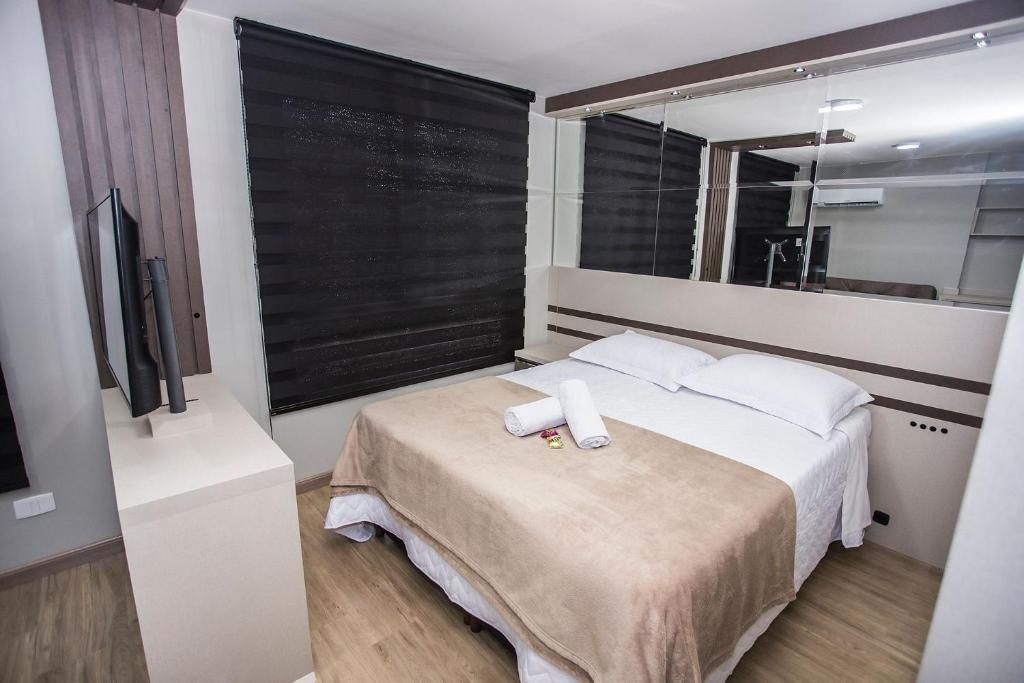ein Schlafzimmer mit einem Bett mit zwei weißen Handtüchern darauf in der Unterkunft Studio com Cama e Sofá-Cama de Casal - ALL2011 in Curitiba