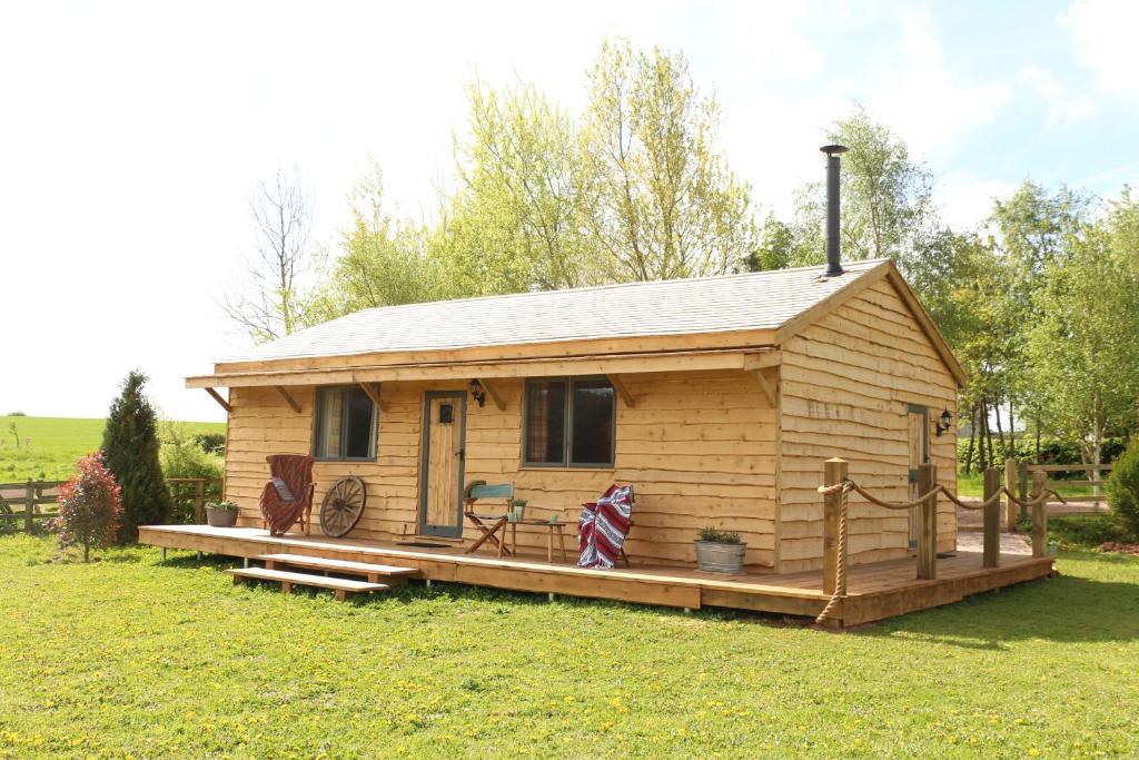 a small wooden cabin with a large deck at Wranglers Den in Bilsthorpe