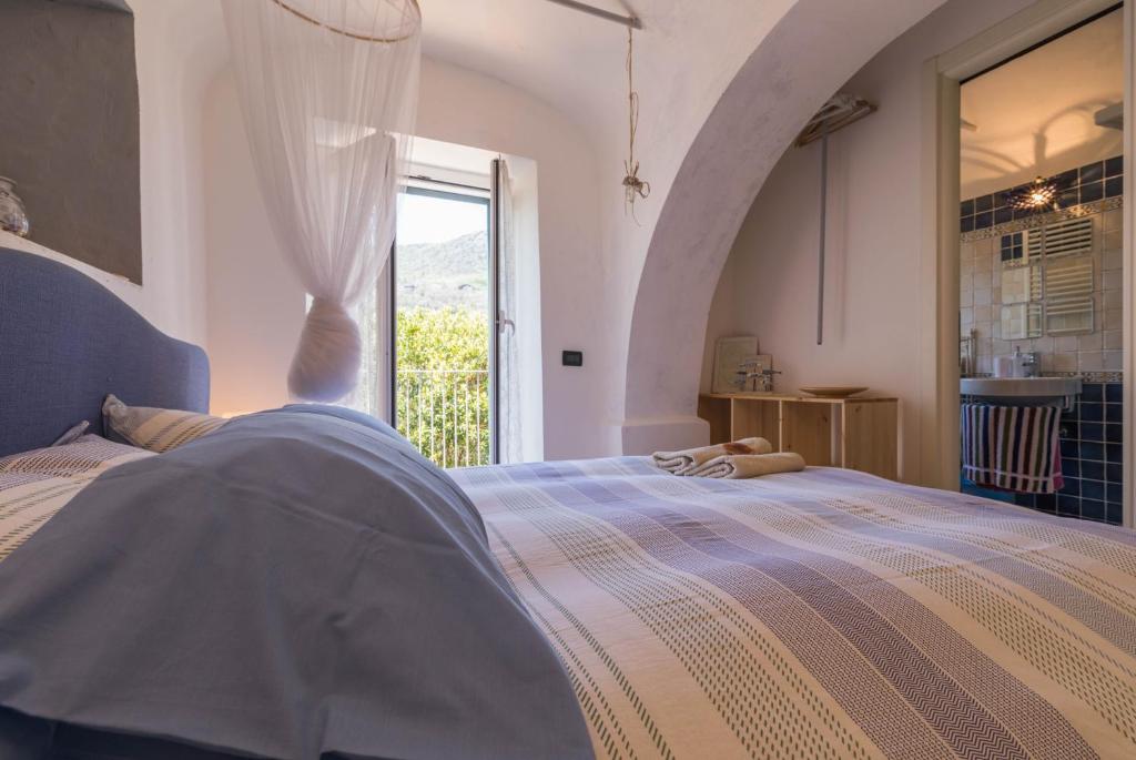 1 dormitorio con cama y ventana grande en La Casa di Sandra a Noli en Noli