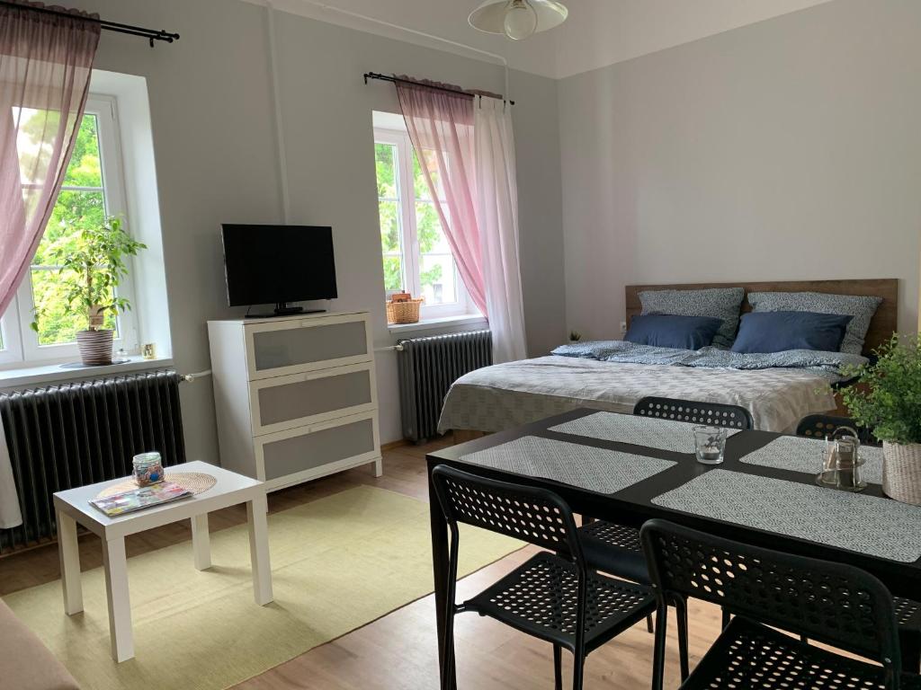 1 dormitorio con 1 cama y 1 mesa con sillas en Négy évszak Apartman- Tapolca, en Tapolca