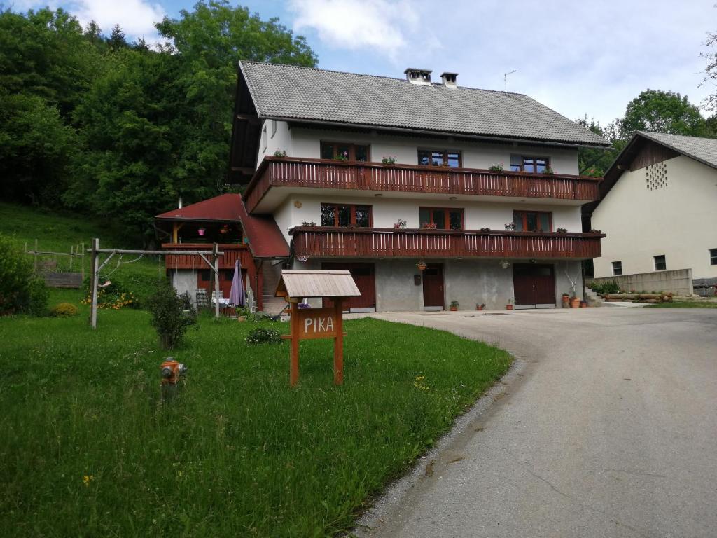 une grande maison avec un panneau en face de celle-ci dans l'établissement Apartmaji Pika, à Cerklje na Gorenjskem