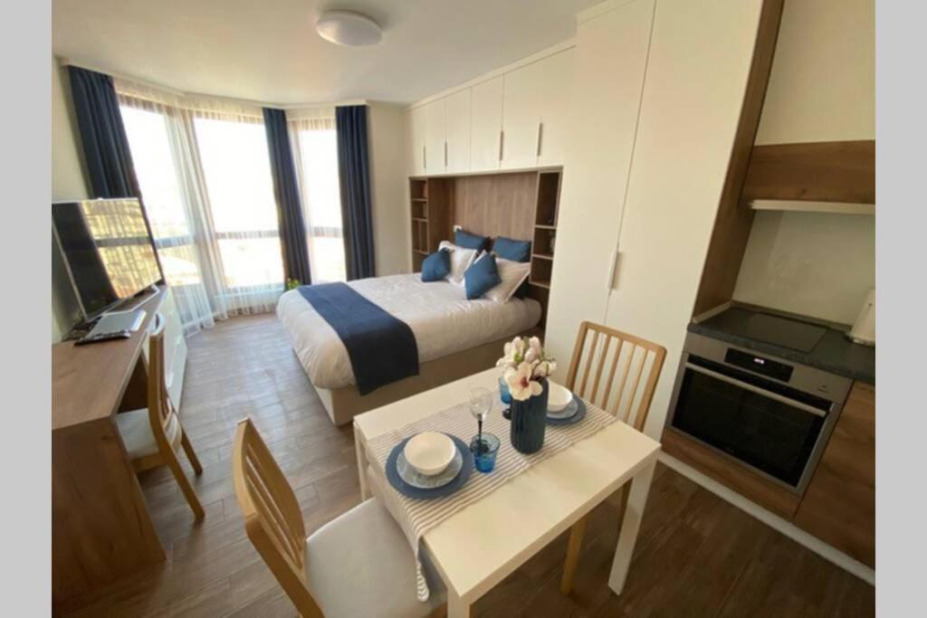 a hotel room with a bed and a table with a kitchen at Studio 13 in Varna City