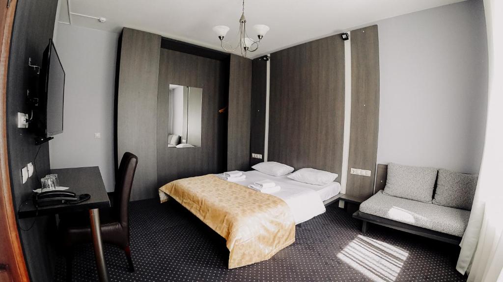 カリーニングラードにあるVilla Tatiana on Lineinayaのベッドと椅子付きのホテルルーム