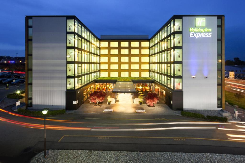 a building with a large sign on the side of it at Holiday Inn Express Zürich Airport, an IHG Hotel in Rümlang