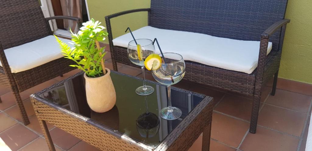 una mesa con dos copas de vino y una planta en Casa Cordieira, en Combarro