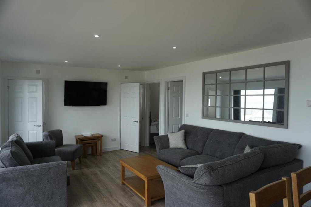 a living room with two couches and a tv at Deluxe Lundy View Villa With Sea Views in Westward Ho