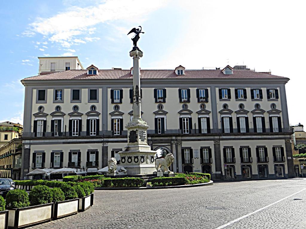 ein großes Gebäude mit einer Statue davor in der Unterkunft Blue Flat in Neapel
