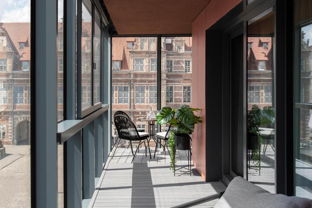 a balcony with a table and chairs and windows at Blue Mandarin Old Town in Gdańsk